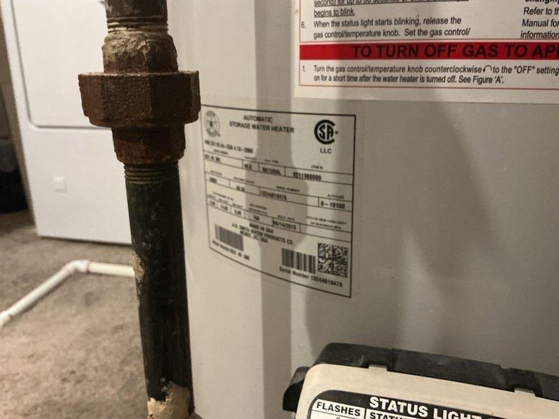 Provided estimate for replacement of existing water heater with a 10-year A.O. Smith unit. Documented current installation showing significant corrosion on metal piping and fittings, photographed existing water heater specifications and surrounding plumbing connections including copper supply lines with shutoff valves and venting system.