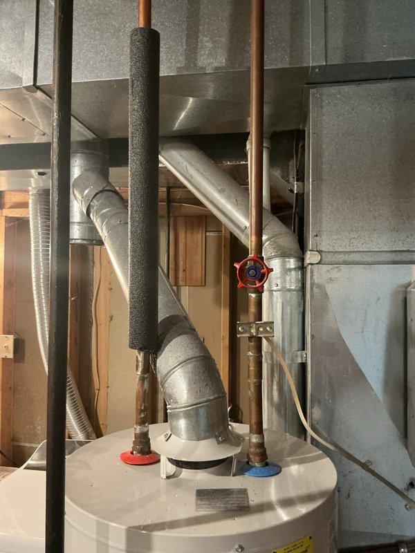 Provided estimate for replacement of existing water heater with a 10-year A.O. Smith unit. Documented current installation showing significant corrosion on metal piping and fittings, photographed existing water heater specifications and surrounding plumbing connections including copper supply lines with shutoff valves and venting system.