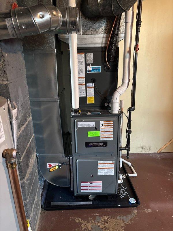 Completed full HVAC system replacement including outdoor condensing unit and indoor air handler/furnace. Outdoor unit installed on existing concrete pad with proper electrical disconnect, condensate drain lines, and refrigerant line connections. Indoor equipment positioned in basement utility area with new ductwork connections, PVC condensate drainage, and proper clearances maintained per manufacturer specifications.