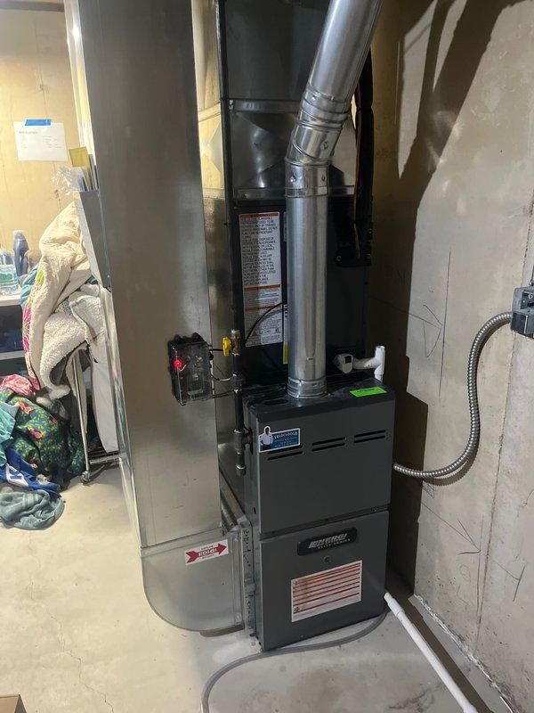 Successfully completed a full HVAC system replacement and water heater installation in the basement utility area. Removed existing air conditioning system and installed new black furnace unit with metallic supply and return ductwork, properly secured between wall studs with all ventilation and safety labels visible. Installed new Bradford White residential water heater with copper supply lines, brass shut-off valves, and blue thermal expansion tank mounted to the side with proper pressure relief connections. All plumbing connections completed with code-compliant materials, electrical conduit run for power supply, and exhaust venting installed per manufacturer specifications. System tested and verified operational upon completion.