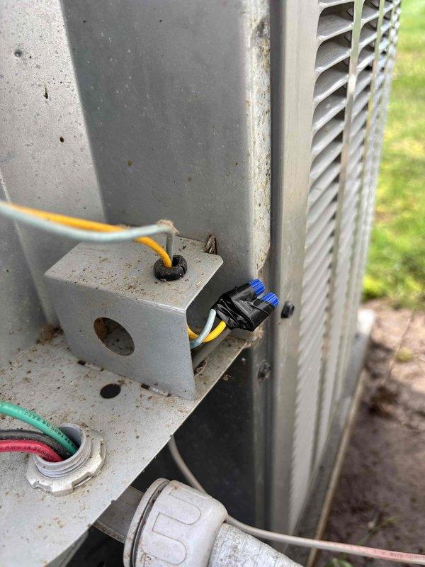 Completed annual heating and cooling maintenance visit including furnace and air conditioning tune-ups for a system without humidifier. Inspected electrical connections, refrigerant line fittings, and service ports on outdoor condensing unit, verifying all components were secure and functioning properly. Documented equipment condition with photos showing exterior service panel connections, refrigerant lines with insulation, and line set installation along building exterior.