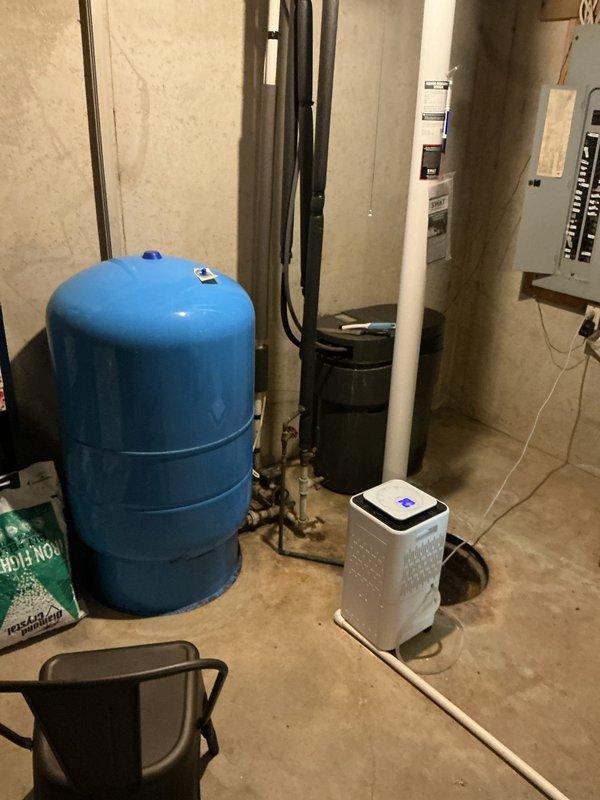 Completed installation of whole-house water softener system in thirty-year-old residential property per quote provided one year prior. System was installed in basement utility area adjacent to existing water heater and pressure tank, with all plumbing connections made to integrate softener into main water supply line. Installation included proper placement of equipment, connection of supply and discharge lines, and verification of system operation upon completion.