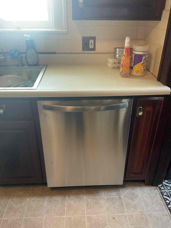 Installed new stainless steel dishwasher in residential kitchen, connecting water supply line and ensuring proper drainage hookup. Unit was tested for leaks and proper operation, with all connections verified secure and functional.