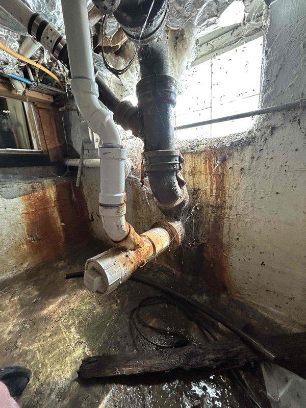 Responded to emergency sump pump failure in crawl space with active water backup. Upon arrival, found existing sump pump system completely non-operational with standing water in pit and visible water damage throughout the utility area. Removed failed sump pump unit and assessed pit condition. Installed new replacement sump pump with appropriate discharge piping connections. Noted extensive corrosion on existing brass discharge pipe and significant moisture damage to surrounding concrete walls and floor surfaces, indicating long-term water exposure issues. Tested new pump operation and verified proper discharge flow. System restored to full working order with water backup eliminated.