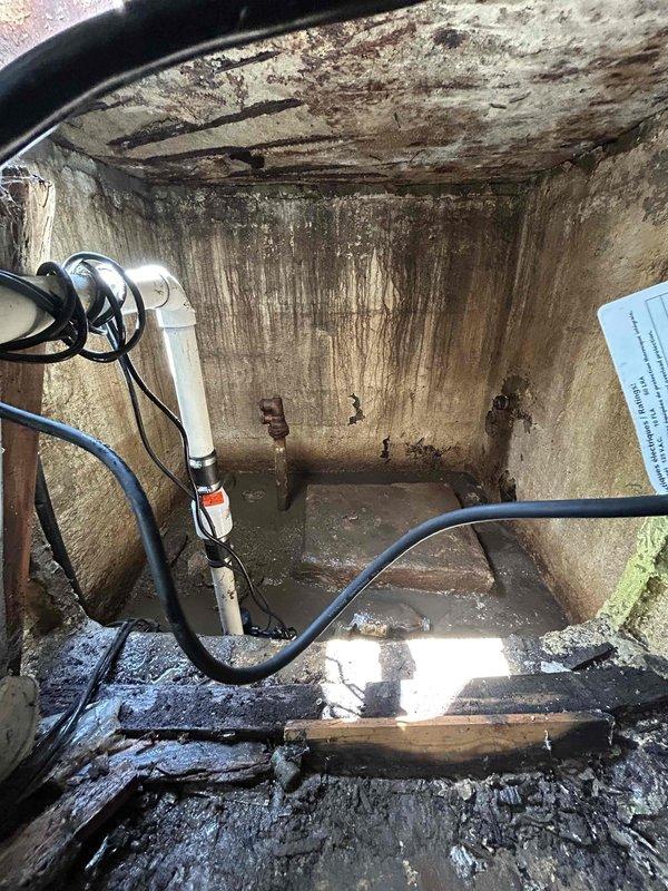 Responded to emergency sump pump failure in crawl space with active water backup. Upon arrival, found existing sump pump system completely non-operational with standing water in pit and visible water damage throughout the utility area. Removed failed sump pump unit and assessed pit condition. Installed new replacement sump pump with appropriate discharge piping connections. Noted extensive corrosion on existing brass discharge pipe and significant moisture damage to surrounding concrete walls and floor surfaces, indicating long-term water exposure issues. Tested new pump operation and verified proper discharge flow. System restored to full working order with water backup eliminated.
