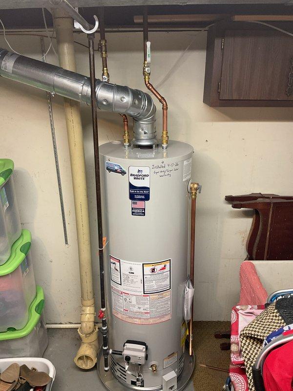 Completed installation of a 40-gallon tall natural gas water heater (Bradford White model M2LQ7G3N) with 6-year tank and 6-year parts warranty in residential utility area. Installation included proper connection of copper supply lines with brass fittings, gas line hookup, and integration with existing ventilation ductwork system, ensuring all manufacturer specifications and safety requirements were met per code.