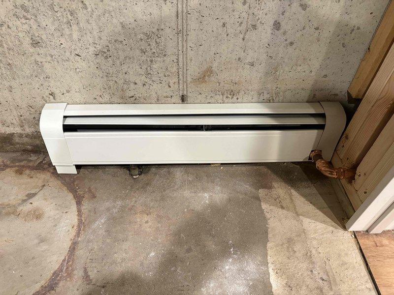 Replaced deteriorated baseboard heating unit in basement area. Removed and disposed of corroded pipe fittings showing significant mineral buildup and corrosion at connection points. Installed new baseboard heater with proper copper piping connections to restore heating functionality in space affected by moisture damage.