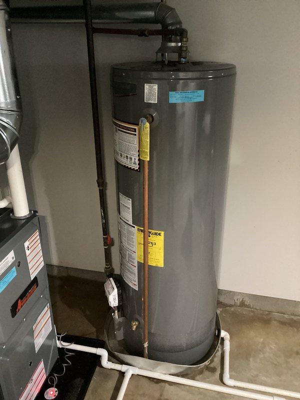 Responded to no heat call where water heater was actively spraying water onto furnace equipment. Upon arrival, confirmed water leak originating from water heater tank affecting nearby HVAC system. Observed red indicator light illuminated on furnace control board, likely due to water intrusion from leaking water heater. Documented conditions with photos showing water heater installation, copper and PVC piping connections, and proximity to furnace unit in basement utility space. Advised customer that water heater requires immediate replacement and furnace control board may need evaluation once water source is eliminated.