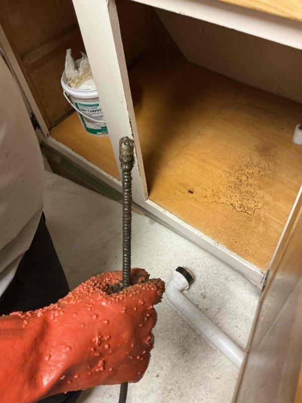 Cabled kitchen sink drain line to clear obstruction and replaced two basket strainers in double-basin sink. Drain system restored to proper operation with no leaks detected upon completion.