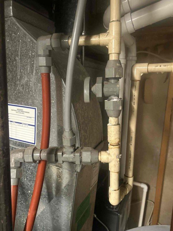 Responded to water heater leak call and conducted thorough inspection of the unit and surrounding plumbing infrastructure. Upon examination of the basement mechanical area, documented the HVAC system, water heater installation, and associated PVC drainage piping network. Photographed the condensate drainage system, including multiple PVC pipes with proper fittings and connections running to the main drain line. Inspected all visible plumbing components, pipe connections, and mechanical equipment for signs of active leakage or moisture damage. System evaluation completed with photographic documentation of current installation conditions for service records.