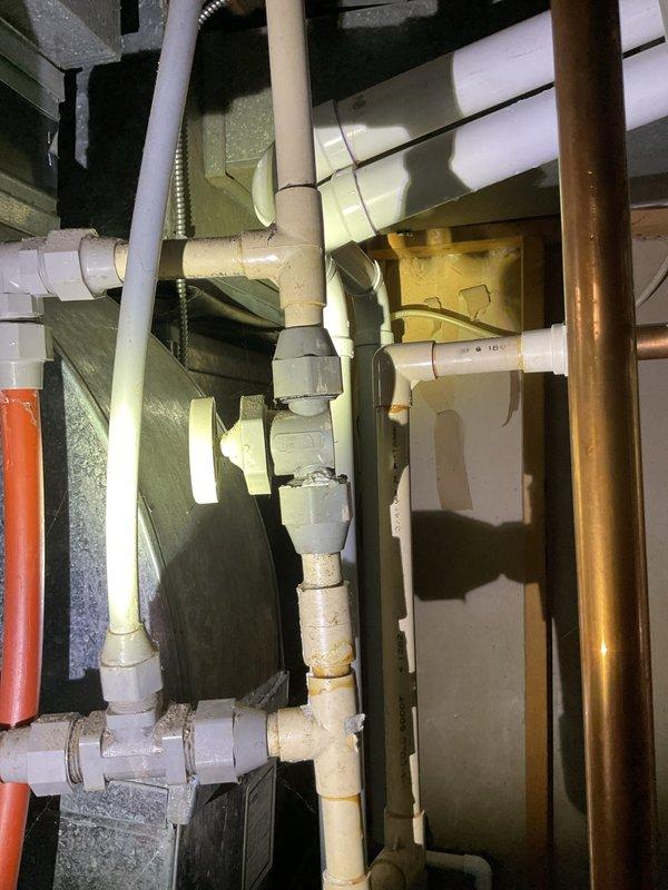 Responded to water softener leak call and performed on-site inspection of plumbing system in basement utility area. Upon examination of the water softener installation, identified multiple plumbing connections including PEX, PVC, copper, and threaded pipe assemblies converging in the service area. Documented existing plumbing configuration showing various pipe materials and junction points to assess leak source and recommend appropriate repairs.
