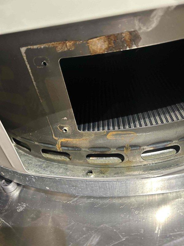 Responded to service call for water heater with water accumulation in drain pan and unit not operational. Upon inspection, discovered significant rust and corrosion on internal components including heat exchanger fins and metal housing panels, indicating prolonged moisture exposure and deterioration of critical components. Documented extensive rust damage with photographic evidence showing advanced corrosion on upper housing sections and rust streaking on ventilation panels. Due to severity of corrosion damage compromising unit integrity and safety, recommended immediate water heater replacement. Unit age and condition of deteriorated components determined repair to be unfeasible.