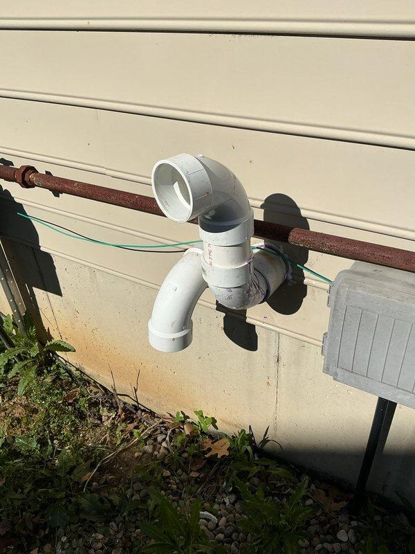 Responded to furnace rattling noise complaint on 11-year-old Goodman unit. Upon inspection, discovered disconnected condensate drain line at exterior termination point. The white PVC drain pipe had separated from the wall-mounted elbow joint, causing vibration and rattling sounds to transmit through the drainage system when the furnace operated. Reconnected and secured the condensate drain line, ensuring proper drainage flow and eliminating the noise issue. System tested and operating quietly.