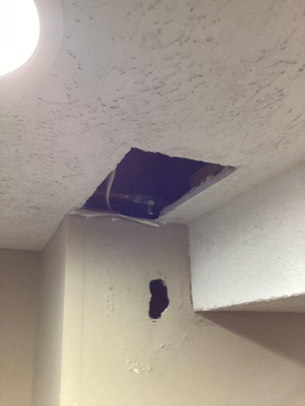 Responded to customer report of water backup in basement. Accessed ceiling and wall cavities to investigate source of water intrusion. Identified copper plumbing line running through affected area with evidence of water damage and staining around opening. Removed drywall sections at ceiling and wall junction to expose plumbing and assess extent of damage. Located leak source and documented conditions with photos showing exposed pipe, wiring, and framing members in compromised area.