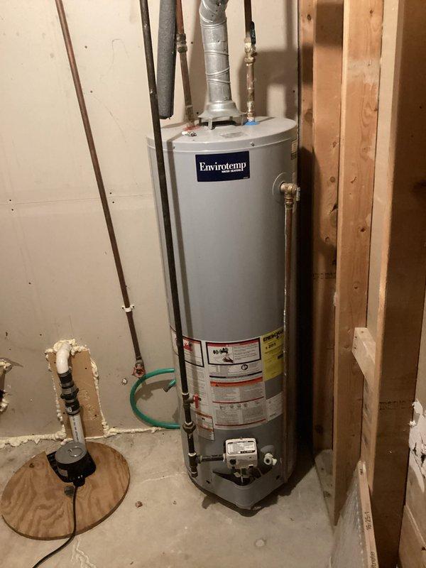 Completed estimate for water heater replacement, upgrading from existing 40-gallon Envirotemp unit to 50-gallon capacity system. Assessed current installation in unfinished basement area, documented existing copper supply line connections, venting configuration, and clearance requirements between wall studs for larger capacity unit installation.