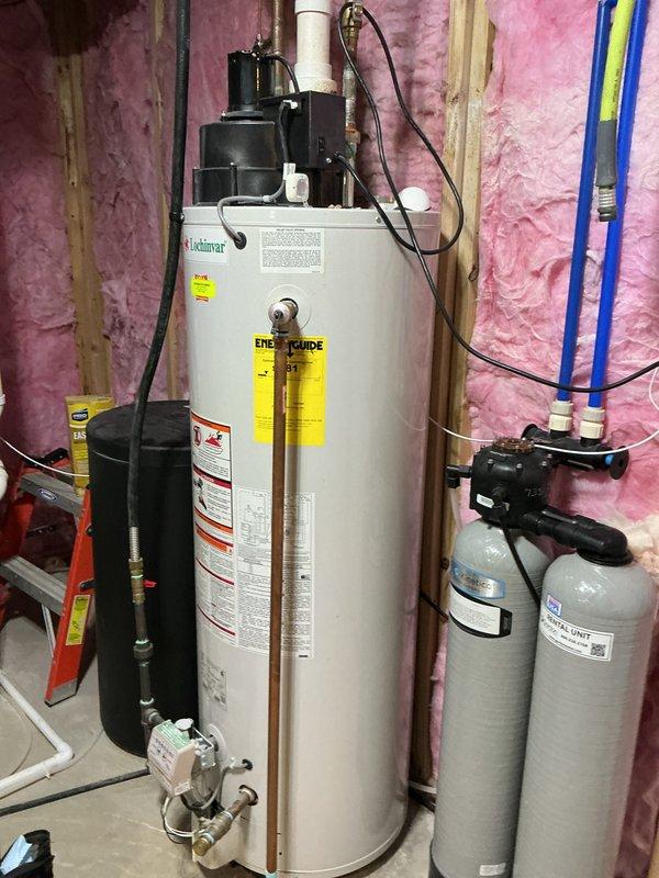 Responded to no hot water complaint on 13-year-old residential water heater. Upon inspection, diagnosed failed heating element in electric water heater located in utility room with associated plumbing components including pressure tank and filtration system. Replaced defective heating element, verified proper electrical connections, tested thermostat operation, and restored full hot water functionality to unit.
