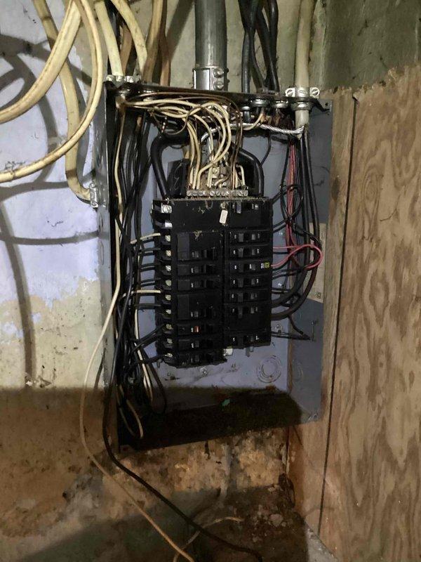 Responded to service call for furnace running but blowing cold air in residence with 30-year-old equipment. Performed diagnostic inspection and documented existing electrical panel and utility area conditions, including aged infrastructure with visible deterioration, moisture damage, and disorganized wiring above main electrical panel. Provided estimate for furnace system evaluation and potential replacement options given age of existing equipment.