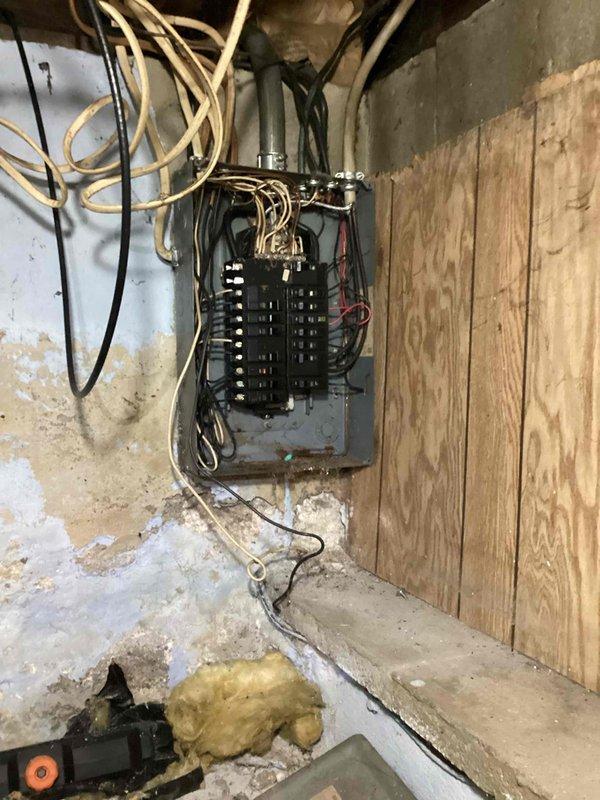 Responded to service call for furnace running but blowing cold air in residence with 30-year-old equipment. Performed diagnostic inspection and documented existing electrical panel and utility area conditions, including aged infrastructure with visible deterioration, moisture damage, and disorganized wiring above main electrical panel. Provided estimate for furnace system evaluation and potential replacement options given age of existing equipment.