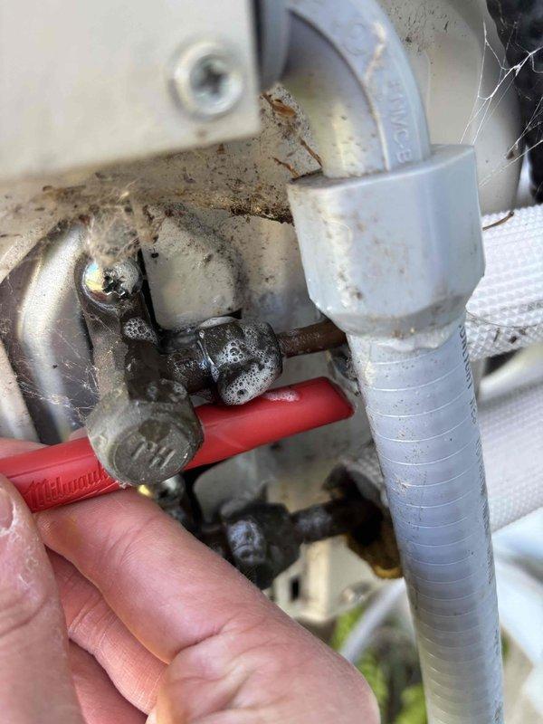 Responded to no cooling complaint on 6-year-old Daikin system with recent circuit board warranty replacement. Performed refrigerant leak inspection at service valves and identified potential leak points at valve connections showing corrosion and age-related degradation. Documented equipment condition with photos showing R-410A refrigerant system components, service ports, and areas of concern for further leak detection and repair recommendations.
