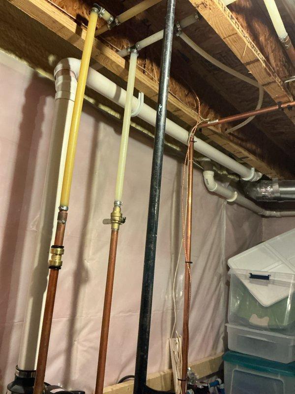 Evaluated existing 11-year-old residential water heater that has completely failed and is no longer operational. Documented current installation including white cylindrical tank water heater with blue Watts circulation pump, copper piping configuration, and integrated black water treatment system. Assessed plumbing connections, mechanical room layout with exposed framing and insulation, and utility infrastructure including gas lines and drainage systems. Provided estimate for complete water heater replacement to restore hot water service to the residence.