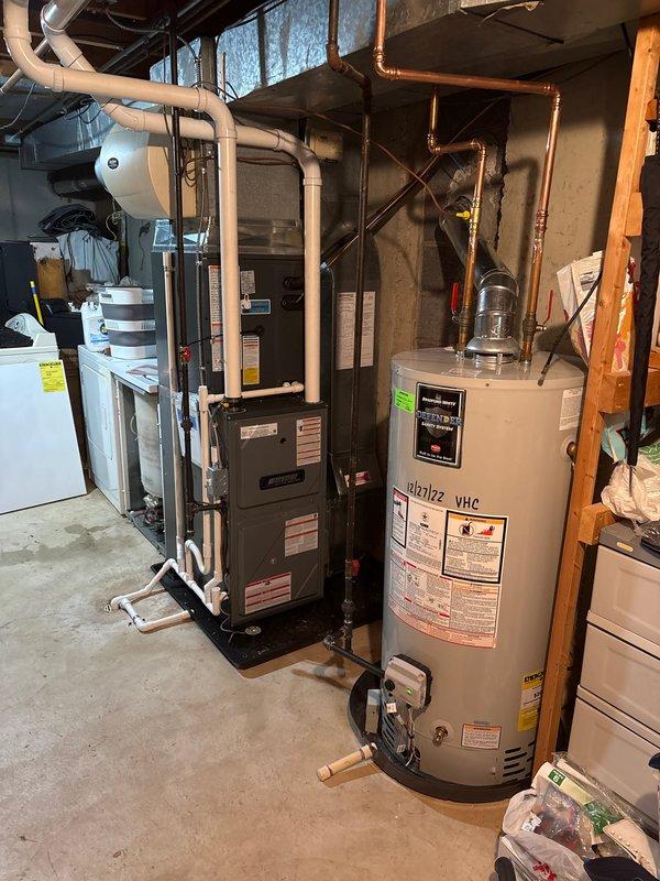 Completed full HVAC system replacement including furnace and air conditioning unit installation in basement mechanical room. Installed new forced-air furnace with proper venting system utilizing white PVC condensate drainage piping, connected copper refrigerant lines to new AC condenser unit, and verified all electrical connections and system specifications. System tested and operational upon completion.