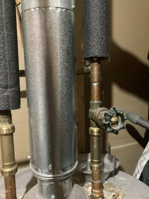 Responded to service call for 10-year-old Whirlpool 67-gallon water heater experiencing inadequate hot water delivery. Upon inspection, assessed existing tank-style water heater installation including copper supply lines, brass fittings, multi-port valve assembly, and proper insulation on hot water distribution piping. Documented current system configuration and mechanical connections. Photographed equipment condition, including galvanized tank exterior, plumbing connections, and associated HVAC ductwork in utility area to support replacement recommendation assessment.