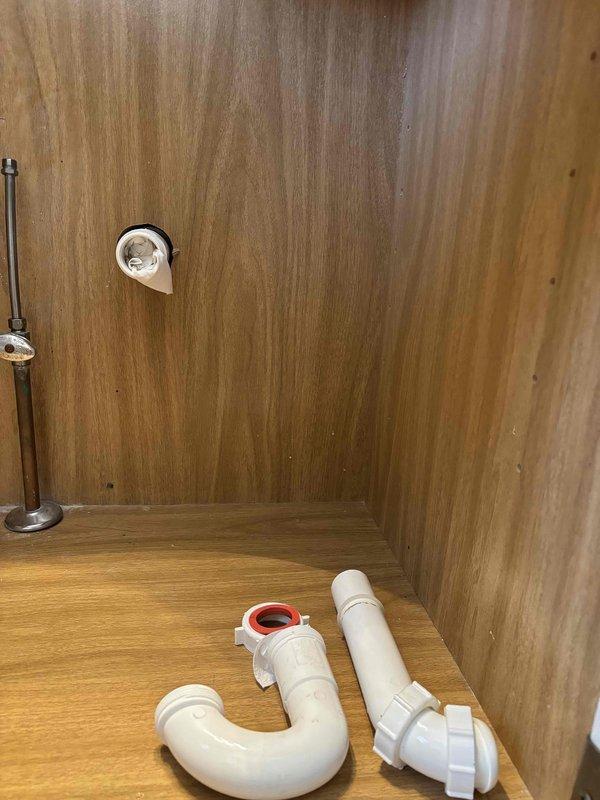 Completed installation of customer-supplied undermount lavatory sink and faucet in bathroom vanity. Removed existing fixture, prepared granite countertop opening, secured undermount sink basin, connected P-trap drainage assembly with white PVC piping, and installed new faucet with complete water supply connections.