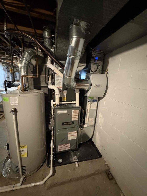 Successfully completed a full HVAC system upgrade consisting of a new furnace installation and air conditioning system addition in a residential basement mechanical room. The furnace was installed with proper metallic ductwork connections extending to the ceiling distribution system, while the outdoor condensing unit was positioned alongside the house exterior with appropriate refrigerant line routing and gravel pad placement. All equipment was properly labeled with refrigerant safety classifications (A2L), field charge documentation was completed and affixed to the outdoor unit, and the system was integrated with existing infrastructure including water heater proximity considerations and wall-mounted air quality equipment coordination.