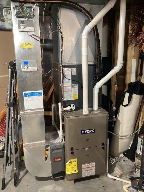 Completed full HVAC system installation including outdoor condensing unit and indoor air handler with York furnace integration. Installed refrigerant lines with proper insulation, electrical connections via flexible metal conduit, and PVC vent piping for exhaust and intake. System charged with refrigerant to manufacturer specifications, tested all controls and thermostats, verified proper airflow through ductwork connections, and confirmed operational parameters within acceptable range.