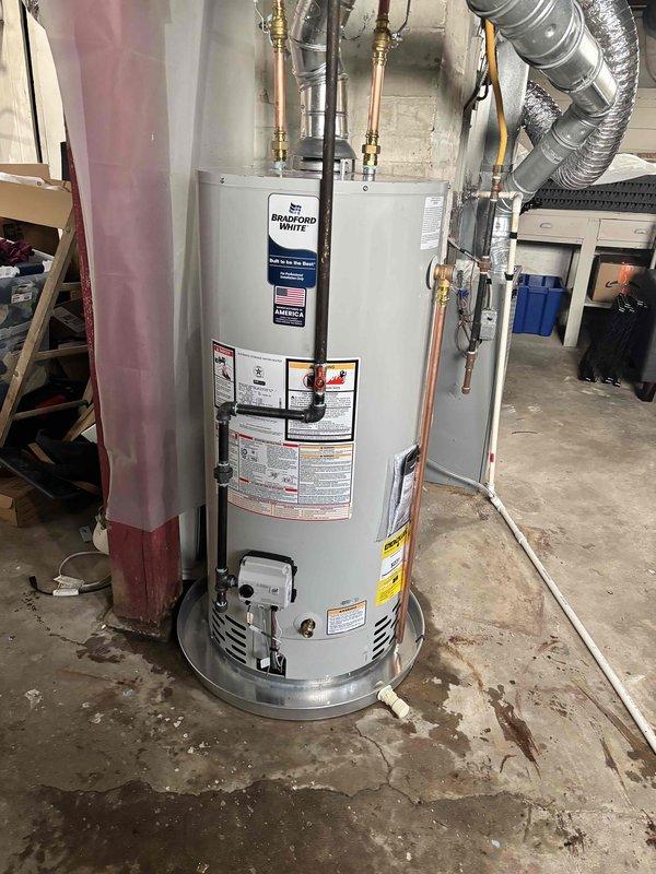 Completed full residential water heater replacement in basement utility area. Removed existing unit and installed new Bradford White water heater with proper copper piping connections, brass fittings, and metallic flexible venting. Ensured all manufacturer specifications, safety labels, and warning notices were properly displayed. Verified proper connections to existing plumbing system and electrical panel, tested unit operation, and confirmed compliance with residential installation standards.