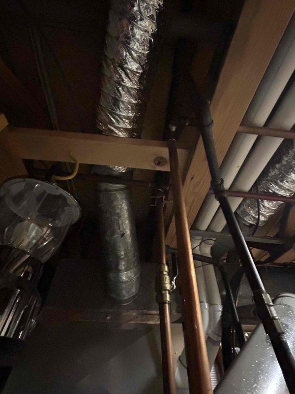 Conducted on-site evaluation for conversion from traditional tank-style water heater to tankless system. Assessed existing attic installation including current water heater location, copper supply lines, gas connections, and venting infrastructure. Documented existing HVAC ductwork configuration and spatial constraints to determine optimal placement and routing for new tankless unit installation.