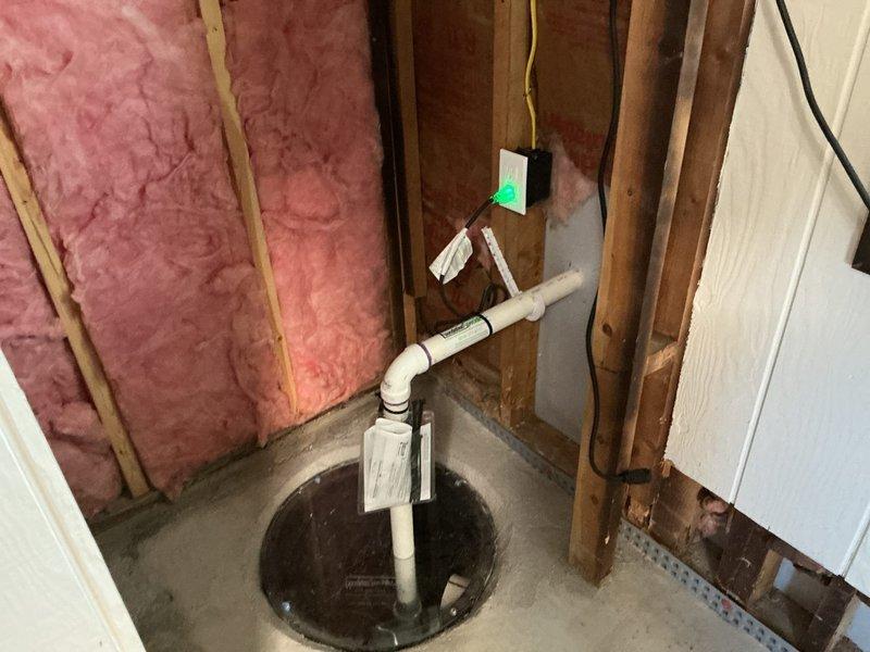 Completed electrical estimate for installation of a dedicated 120-volt circuit to power an existing sump pump system in a 50-year-old residential property. Assessed the existing electrical panel, which contained adequate breaker space and capacity for the new circuit installation. Evaluated the routing requirements from the main panel through the unfinished basement area to the sump pump location, noting the exposed stud construction and concrete floor conditions. The sump pump assembly included a vertical PVC discharge pipe system with an electronic control device mounted to the wall framing. Recommended installation specifications for a dedicated 15-amp or 20-amp circuit with appropriate GFCI protection per current electrical code requirements for wet locations.