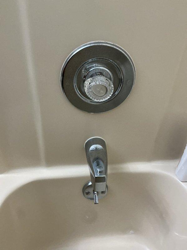 Responded to service call for sticking tub/shower faucet control valve that had become increasingly difficult to operate in 1989-built home. Inspected chrome shower fixture assembly and determined the single-handle diverter valve cartridge required replacement due to mineral buildup and wear causing restricted movement. Removed existing valve trim, extracted worn cartridge, cleaned valve body, and installed new replacement cartridge compatible with existing fixture. Tested operation of both tub spout and showerhead functions to verify proper water flow and smooth handle operation throughout full range of motion. System restored to normal functionality with no leaks detected.