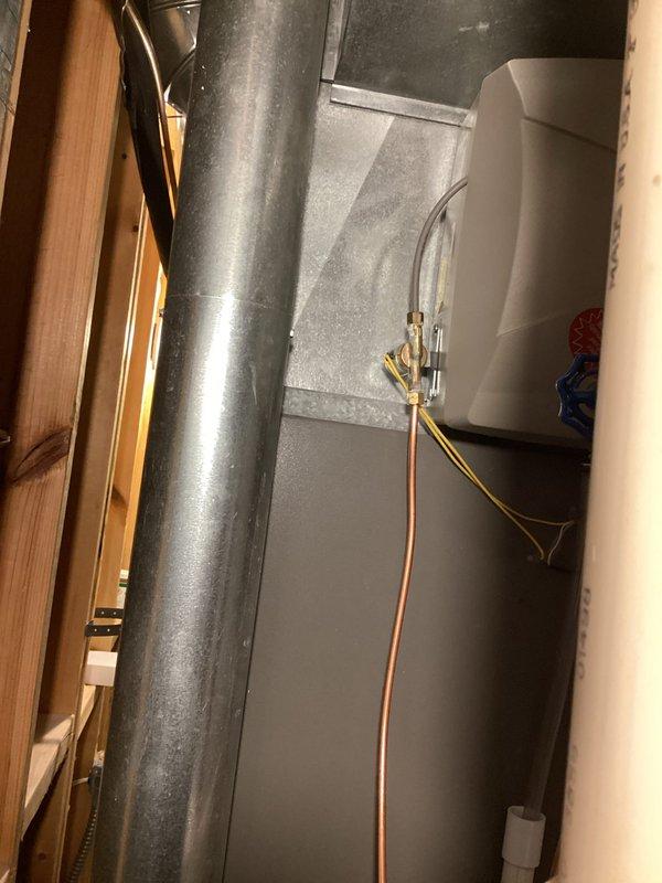 Responded to heating system evaluation for water intrusion concerns. Upon inspection, discovered water stains in condensate drain pan with rust accumulation forming near the condensation drain line on 19-year-old Lennox furnace. Documented existing conditions with photographs showing mechanical room plumbing components, insulated piping, and HVAC equipment layout. Performed comprehensive AC tune-up service in conjunction with furnace evaluation. Assessed drain line functionality and condensate removal system operation. System currently under extended warranty coverage through February 2032. Recommended monitoring condensate drainage and addressing rust buildup to prevent future blockages or overflow conditions.