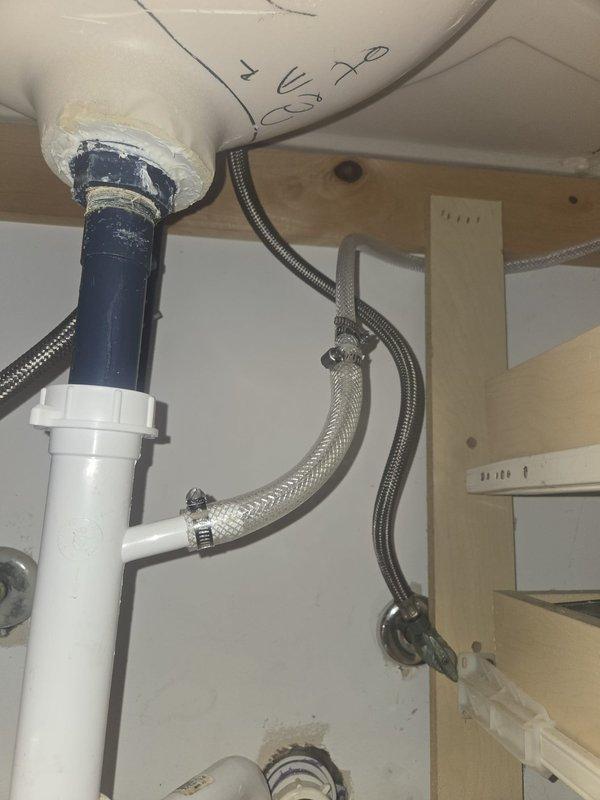 Responded to quoted repair request to evaluate and provide alternative solution for dishwasher discharge hose routing. Upon inspection of under-sink plumbing configuration, assessed existing drainage system including PVC tailpiece connections, supply lines, and cabinet space constraints. Documented current installation with photos showing plumbing layout, supply line positioning, and available routing options within cabinet structure. Evaluated feasibility of alternative discharge hose path to avoid full replacement of existing drain run and provided recommendations for optimal solution.