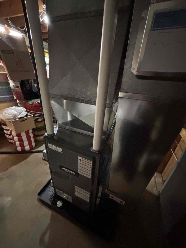 Completed full furnace installation in basement utility area, including new HVAC unit with galvanized metal plenum chamber and metallic ductwork routing. Installed PVC condensate drainage piping, connected all necessary electrical components, and mounted wall-mounted control panel. System tested and verified operational upon completion.