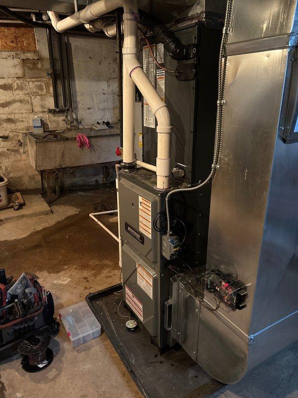 Completed full air conditioning system replacement at residential property. Installed new outdoor condensing unit on concrete pad with proper refrigerant line connections and drainage piping. Connected system to existing furnace and ductwork in basement mechanical room, ensuring proper integration with HVAC infrastructure. All electrical connections, refrigerant lines, and condensate drainage installed per manufacturer specifications. System tested and operational upon completion.