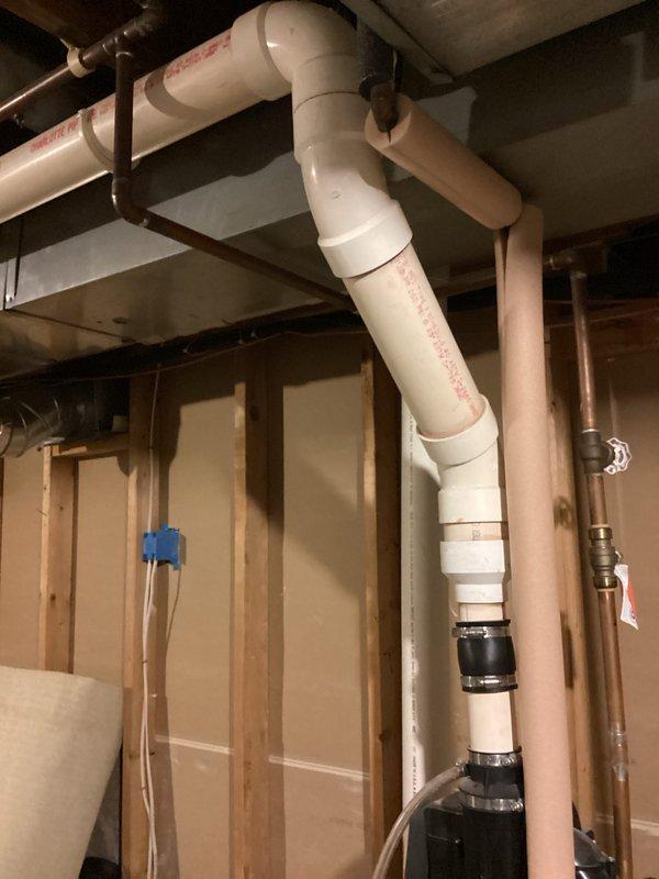 Responded to water heater issue with water accumulation in drain pan beneath 7-year-old unit that was still operational. Upon inspection, documented existing plumbing configuration including PVC drainage system, copper water lines, and associated connections. Photographed installation showing complex pipe routing with proper support brackets and multiple valve locations. Unit assessed for potential leaking, condensation buildup, or temperature/pressure relief valve discharge as possible sources of water in pan.