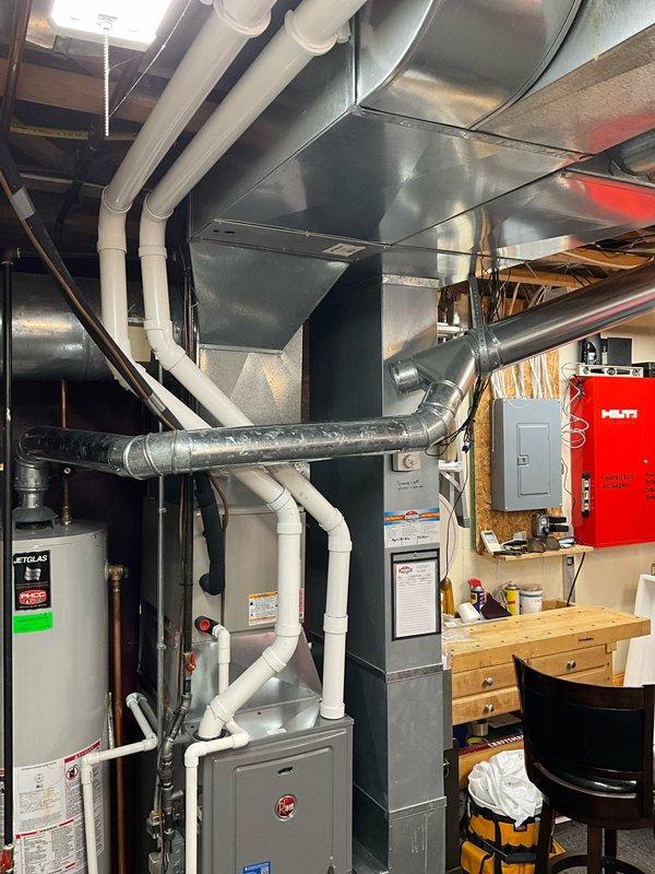 Provided estimate for replacement of 26-year-old Jetglas water heater located in basement mechanical room. Documented existing installation with associated plumbing connections, proximity to furnace and ductwork system, and current configuration of utility area to prepare comprehensive replacement quote.