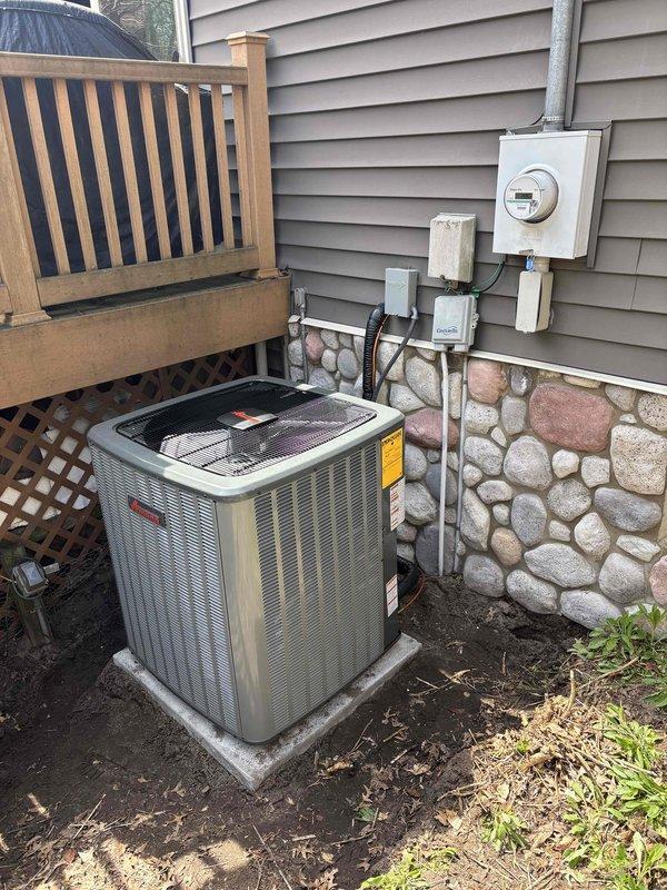 Completed full air conditioning system replacement at residential property. Installed new Amana condenser unit on concrete pad against exterior wall with proper electrical connections, including meter integration and disconnect box. All electrical conduit properly routed and secured to building exterior, system tested and operational.