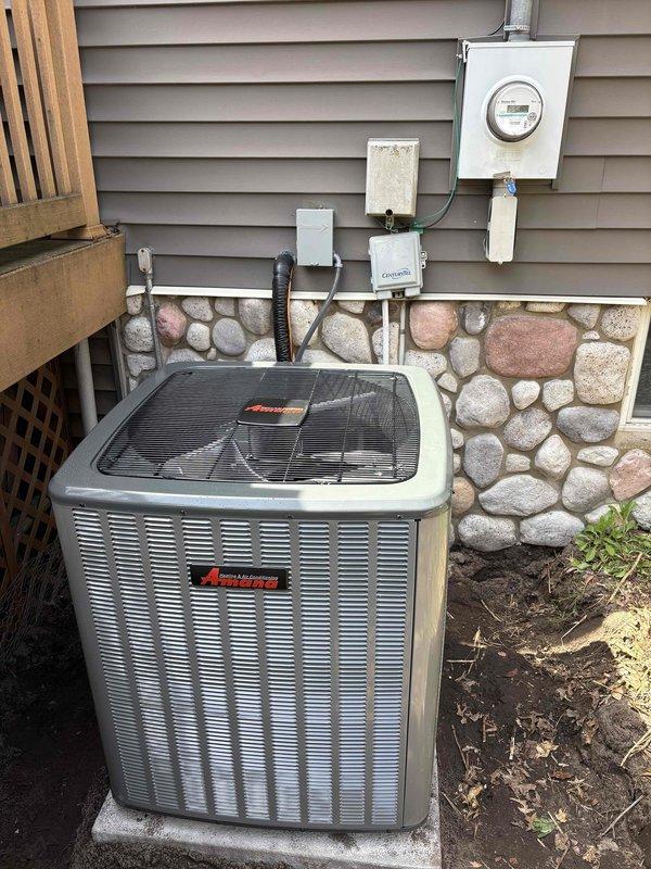 Completed full air conditioning system replacement at residential property. Installed new Amana condenser unit on concrete pad against exterior wall with proper electrical connections, including meter integration and disconnect box. All electrical conduit properly routed and secured to building exterior, system tested and operational.