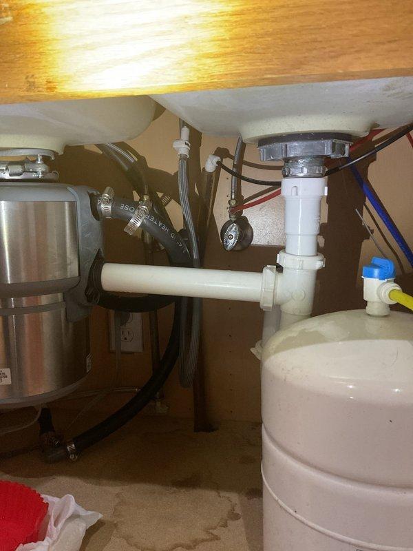 Completed kitchen faucet installation on double basin composite sink with butcher-block countertop. Installed brushed stainless steel faucet with high-arc spout and matching side spray assembly, ensuring proper connections to existing supply lines and adequate clearance for sink operation. Verified all plumbing connections beneath sink were secure, tested water flow and spray functions, and confirmed no leaks at supply lines or drain connections.