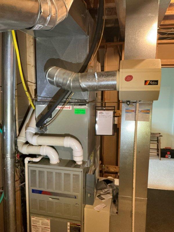 Performed comprehensive tune-up and estimate assessment on 26-year-old residential HVAC system consisting of Amana furnace, air conditioning unit, and humidifier at secondary residence. Conducted thorough inspection of all equipment, ductwork connections, PVC condensate drainage lines, and electrical components in basement mechanical room. Documented existing system configuration with detailed photography showing furnace cabinet with ventilated panels, air handler unit, flexible and rigid metal ductwork, multiple PVC drain lines with proper trap configuration, and overall installation condition for estimate preparation purposes.