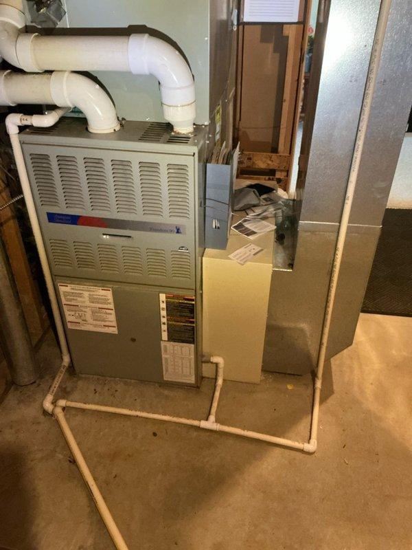 Performed comprehensive tune-up and estimate assessment on 26-year-old residential HVAC system consisting of Amana furnace, air conditioning unit, and humidifier at secondary residence. Conducted thorough inspection of all equipment, ductwork connections, PVC condensate drainage lines, and electrical components in basement mechanical room. Documented existing system configuration with detailed photography showing furnace cabinet with ventilated panels, air handler unit, flexible and rigid metal ductwork, multiple PVC drain lines with proper trap configuration, and overall installation condition for estimate preparation purposes.
