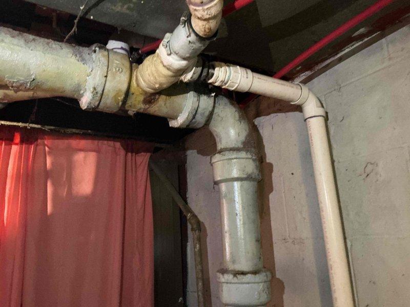 Completed sales estimate for main sewer pipe replacement in basement. Inspected and documented existing plumbing system, which showed significant aging with rust, corrosion, and discoloration on multiple pipe sections including vertical PVC stack and horizontal branch lines. Photographed deteriorated plumbing infrastructure to support estimate preparation, noting that property owner has city grant funding available for the project.