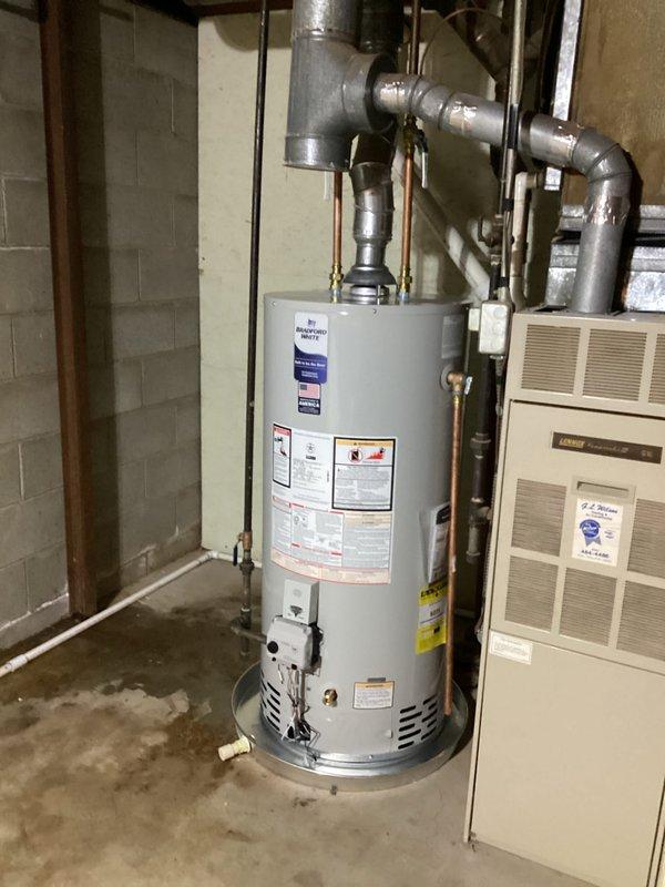 Successfully installed a 40-gallon natural gas water heater (6-year warranty, short model) in basement utility room. Completed all plumbing connections using copper and galvanized steel piping with proper fittings and elbows, secured vertical copper lines with metal support straps, and ensured proper venting configuration. Unit installed adjacent to existing HVAC furnace with all connections tested and verified operational.