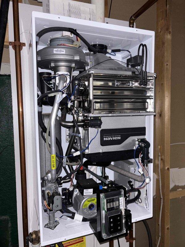 Completed comprehensive tune-up service on an 8-year-old Navien tankless water heater experiencing reduced water pressure. Performed full system inspection, removed and cleaned heavily clogged intake air filter that was significantly restricting airflow, descaled heat exchanger assembly, flushed system components, verified proper operation of all mechanical and electronic controls, and restored unit to optimal performance with improved water pressure output.