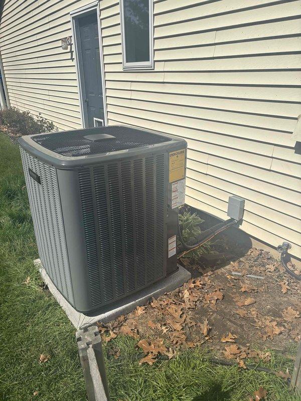 Completed full air conditioning system replacement at residential property. Removed existing outdoor condensing unit and installed new unit on concrete pad against exterior wall with proper clearances maintained. Indoor air handler connected to existing ductwork system in basement utility area with new refrigerant lines, condensate drainage via PVC piping, and electrical connections completed to manufacturer specifications. System tested and verified operational.
