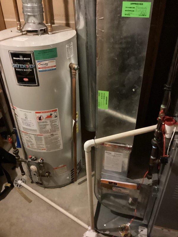 Completed estimate for water heater replacement in residential basement mechanical room. Inspected existing Bradford White water heater with Defender Safety System, documented current installation including copper supply piping, valve configurations, and venting connections. Assessed mechanical room layout with adjacent HVAC ductwork and equipment to determine replacement requirements and clearances for new unit installation.