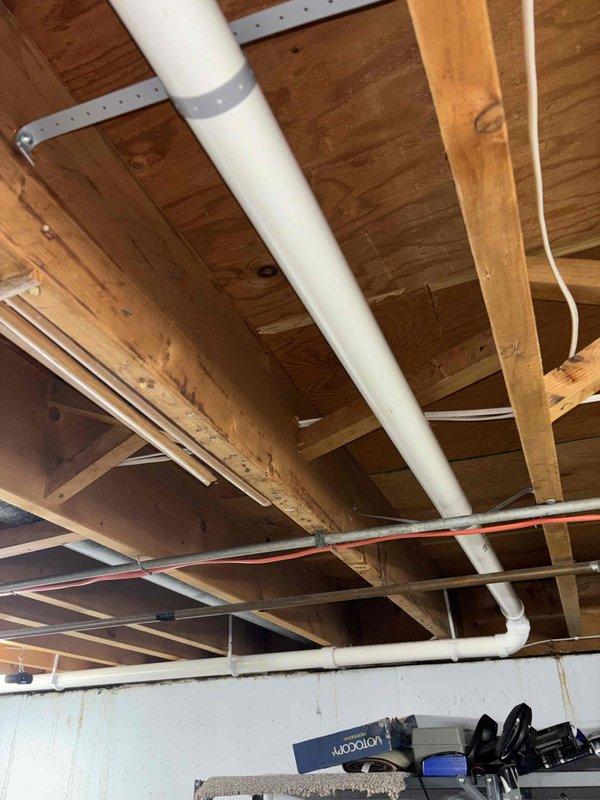 # Plumbing Project Install

Completed drain work installation in basement area, routing new PVC drain lines through exposed ceiling joists using proper hanger strapping and support systems. Installed horizontal drain piping with appropriate slope and secured all lines to structural members per code requirements. Project documented with photos showing completed rough-in plumbing infrastructure ready for inspection.
